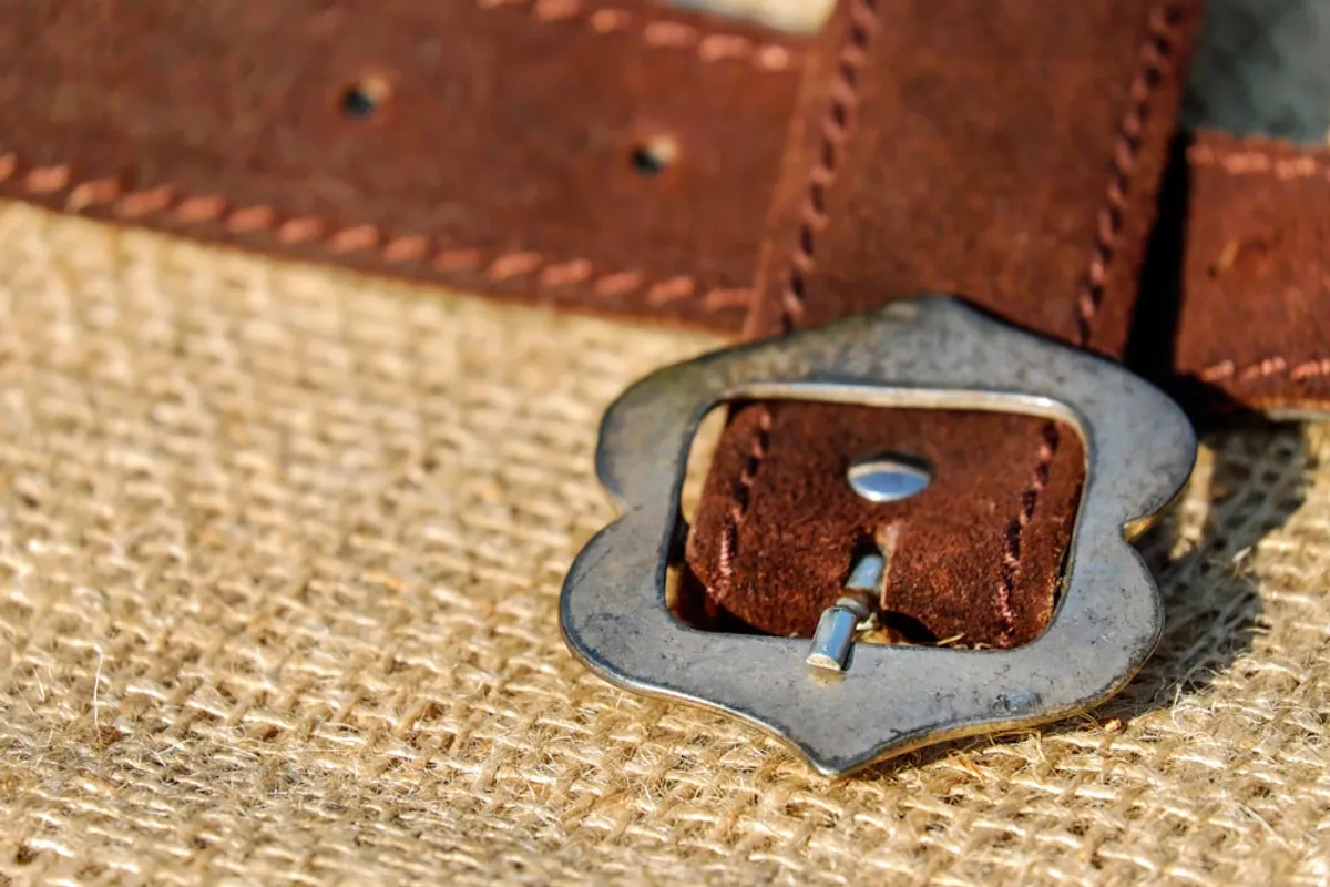 A solid metal buckle and stitched keeper on a hand-finished leather belt